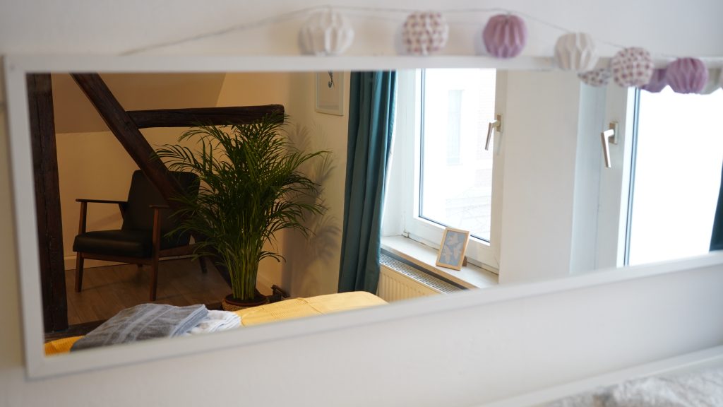 Ein Spiegel hängt über dem Bett, des Gästeapartments